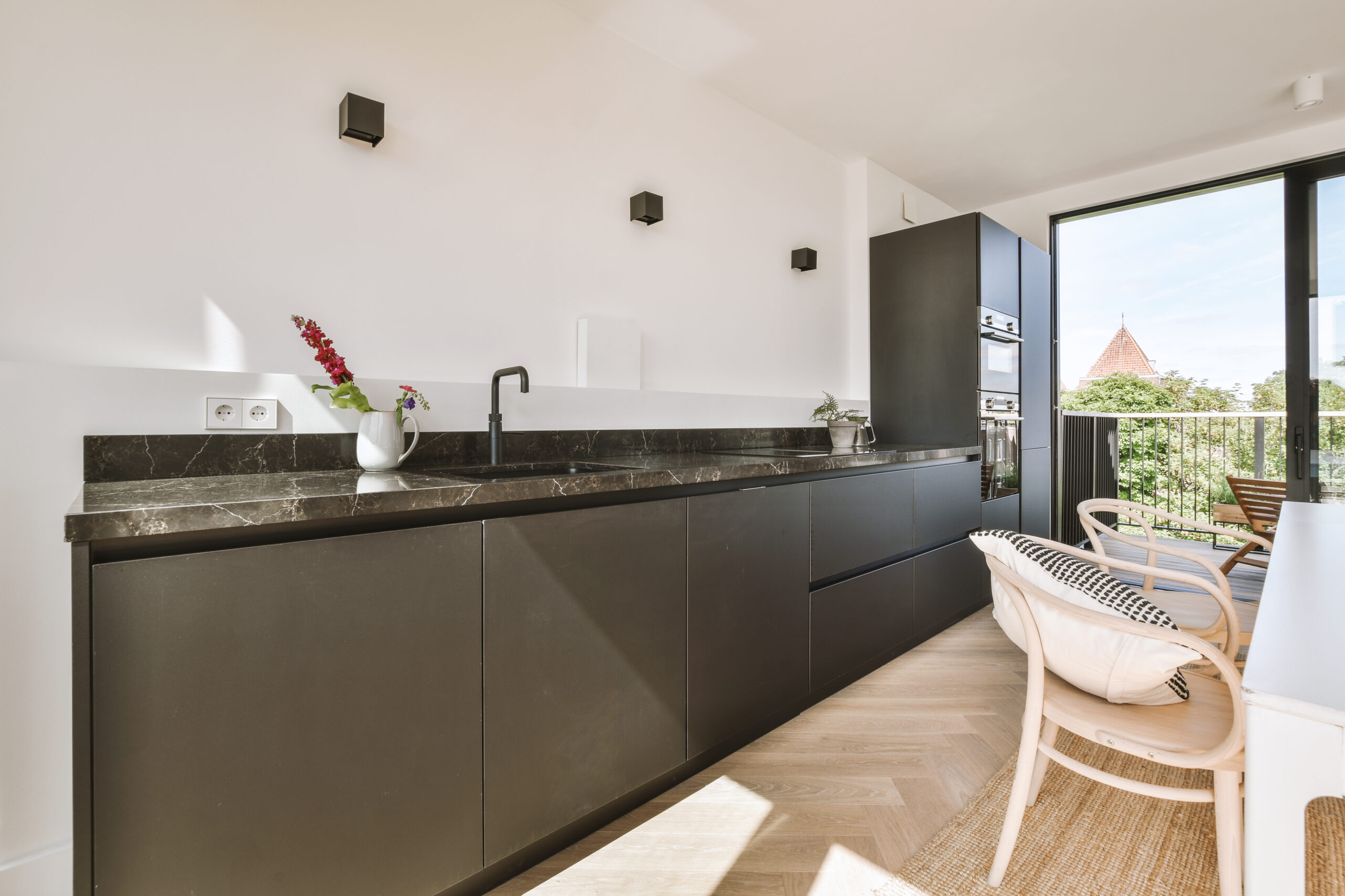 Home interior design of modern loft apartment with open kitchen in minimalist style and spacious dining zone with table and chairs