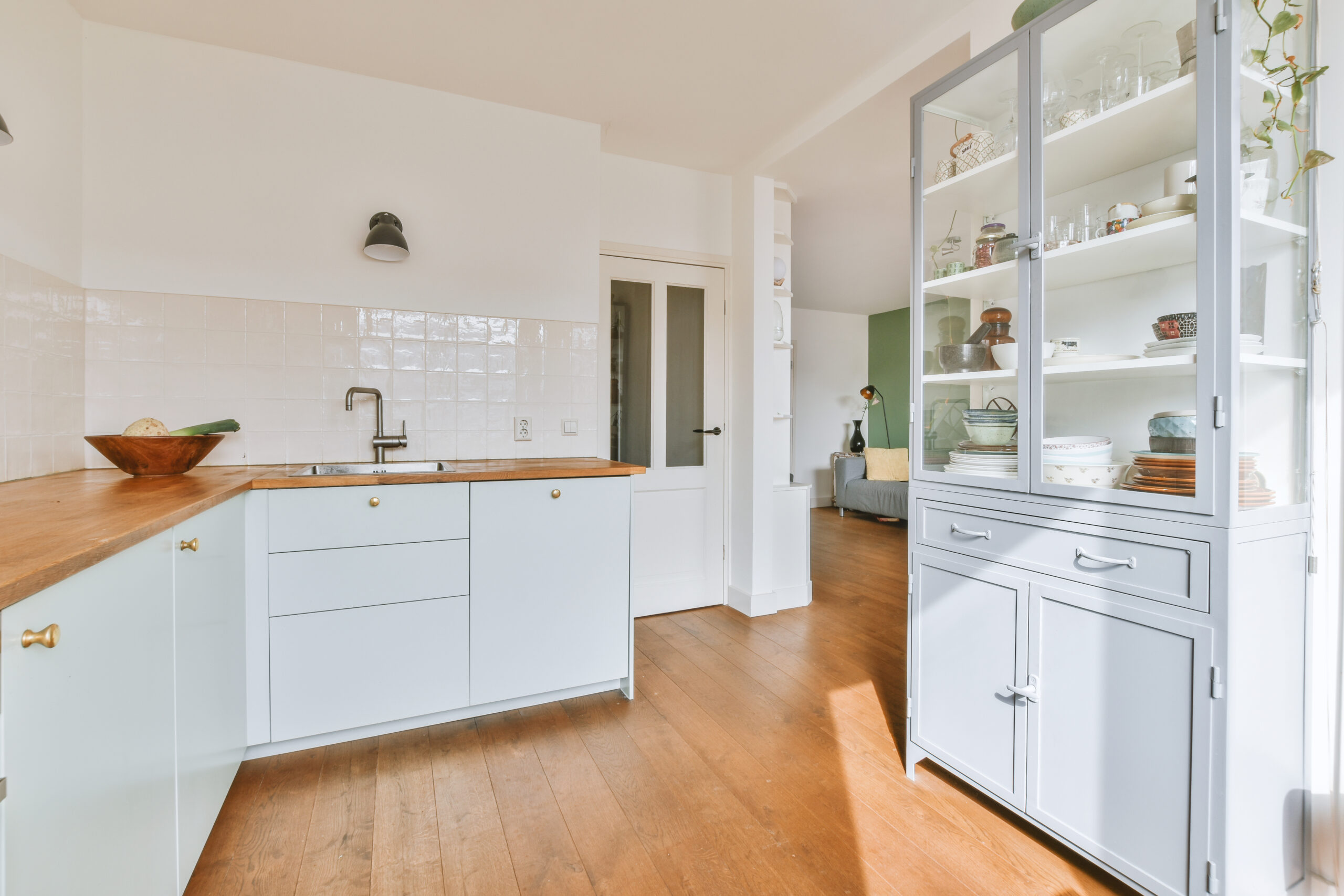 Corner cupboards and table with chairs located in light kitchen of contemporary flat