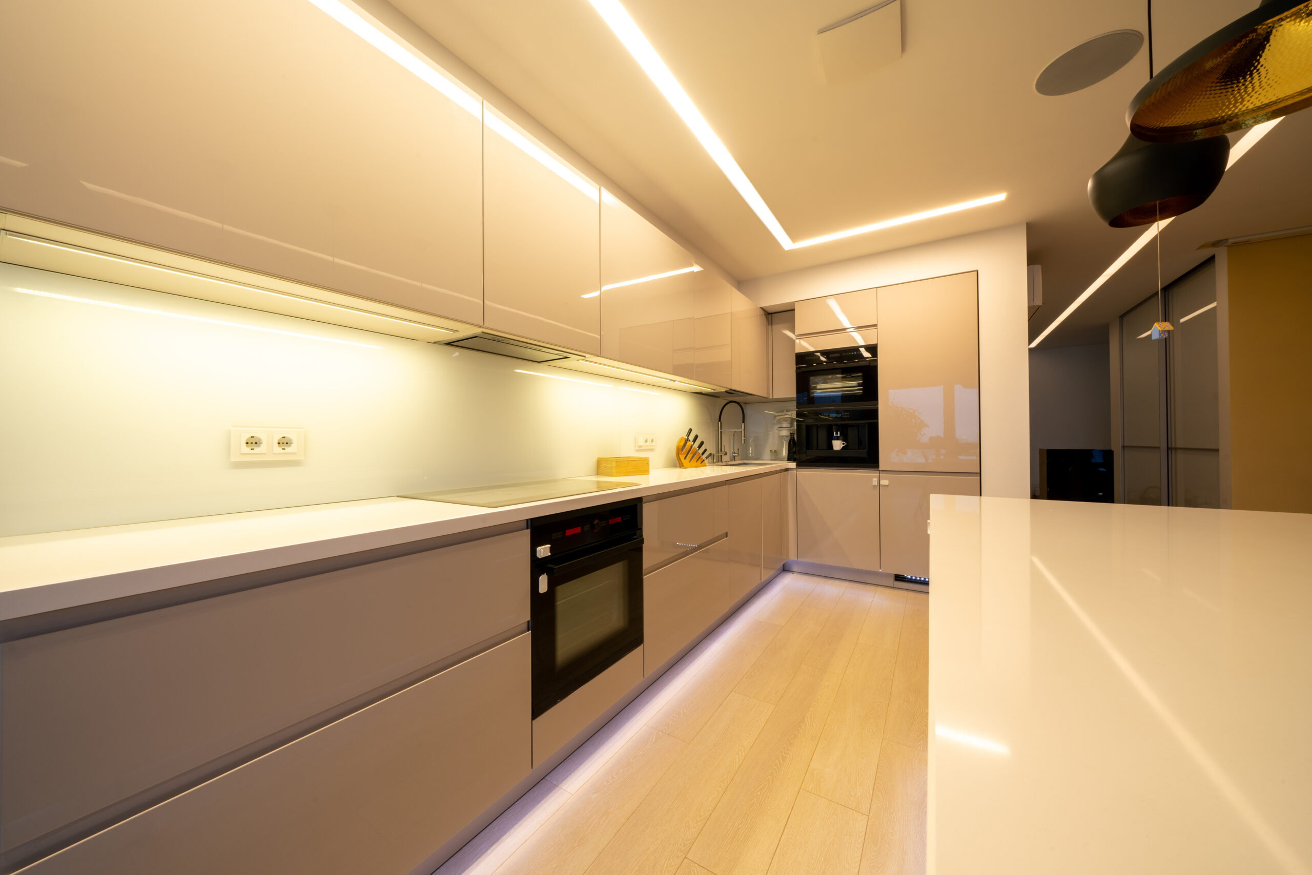 Interior design spacious bright studio apartment in warm pastel beige colors. Trendy furniture in the living area and modern details in the kitchen area