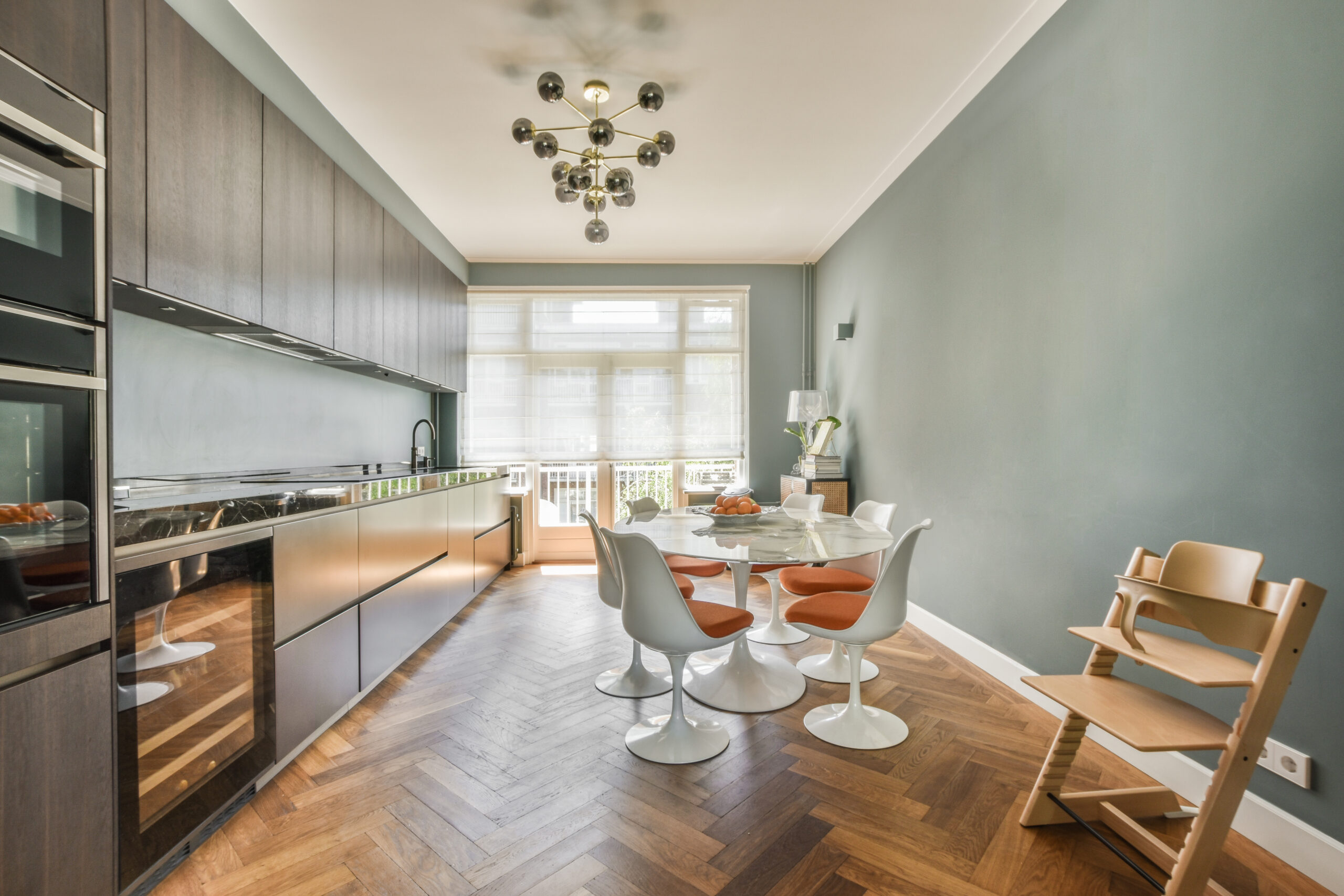 Home interior design of modern loft apartment with open kitchen in minimalist style and spacious dining zone with table and chairs