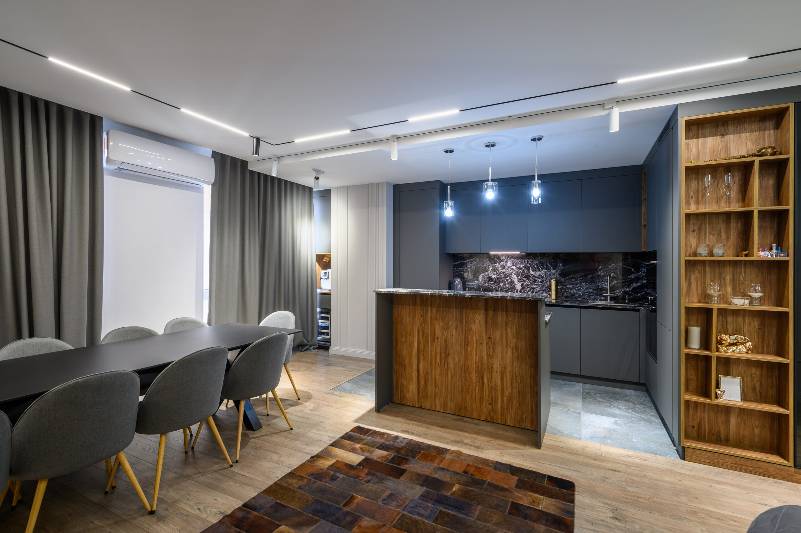 Luxury living room with dining or banquet table and grey kitchen in studio apartment interior