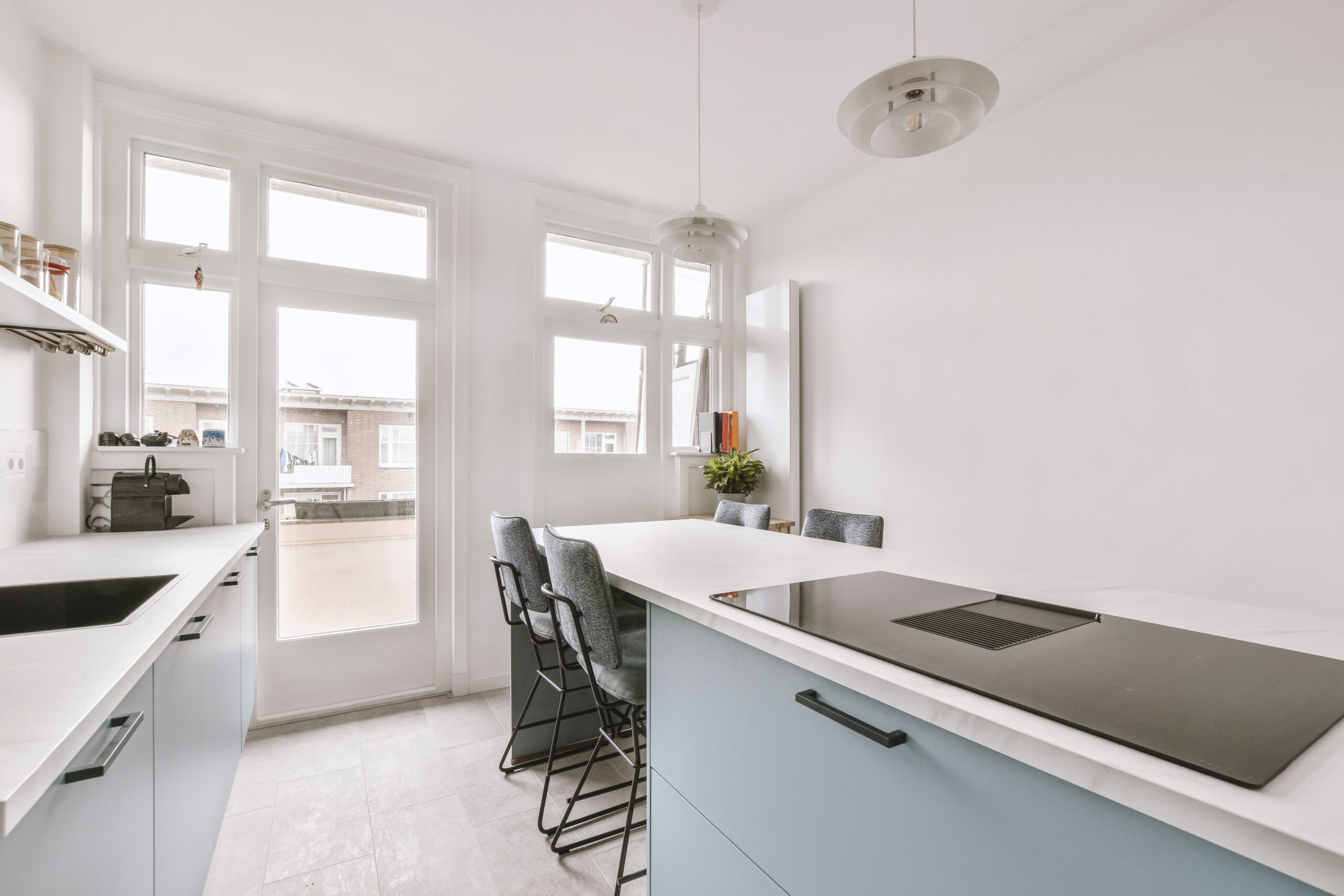 Home interior design of modern loft apartment with open kitchen in minimalist style and spacious dining zone with table and chairs