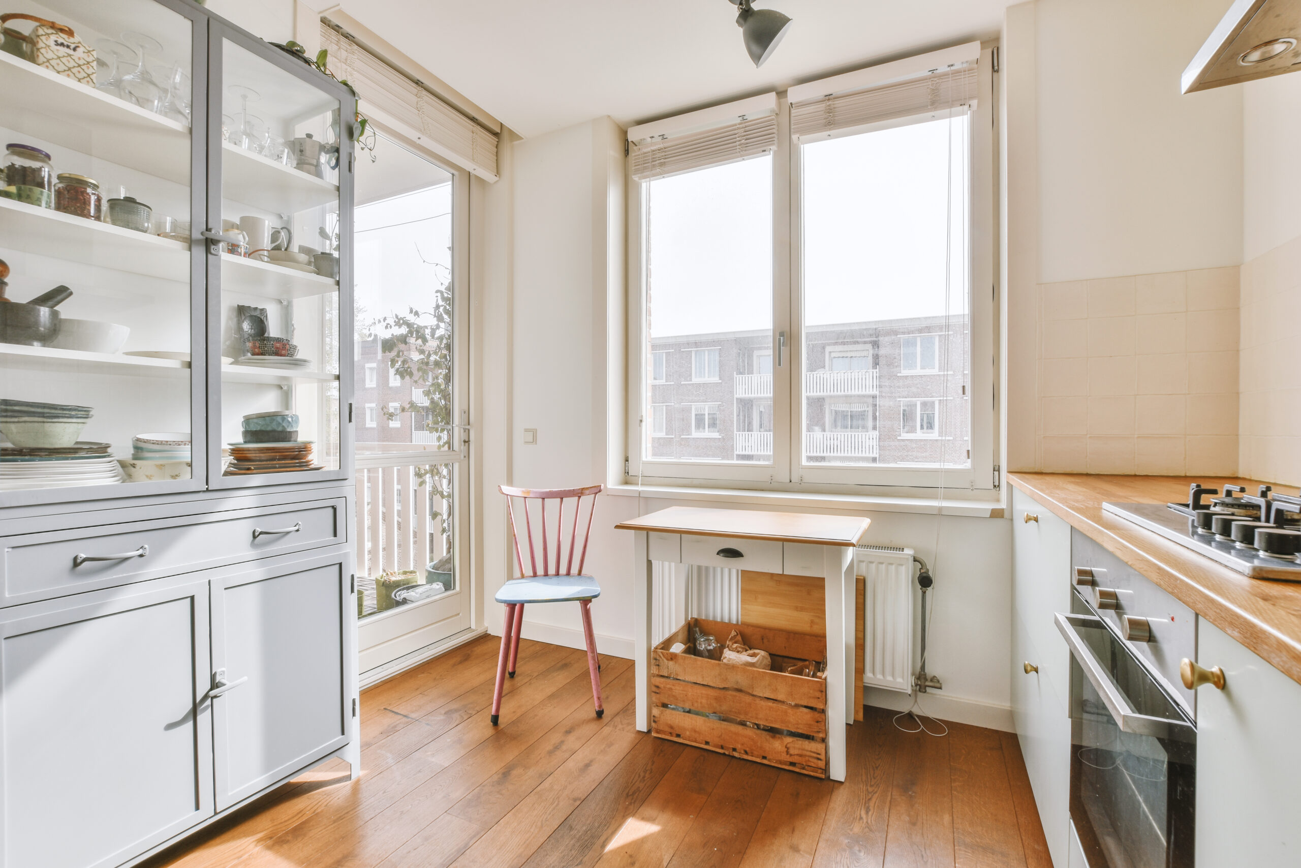 Corner cupboards and table with chairs located in light kitchen of contemporary flat
