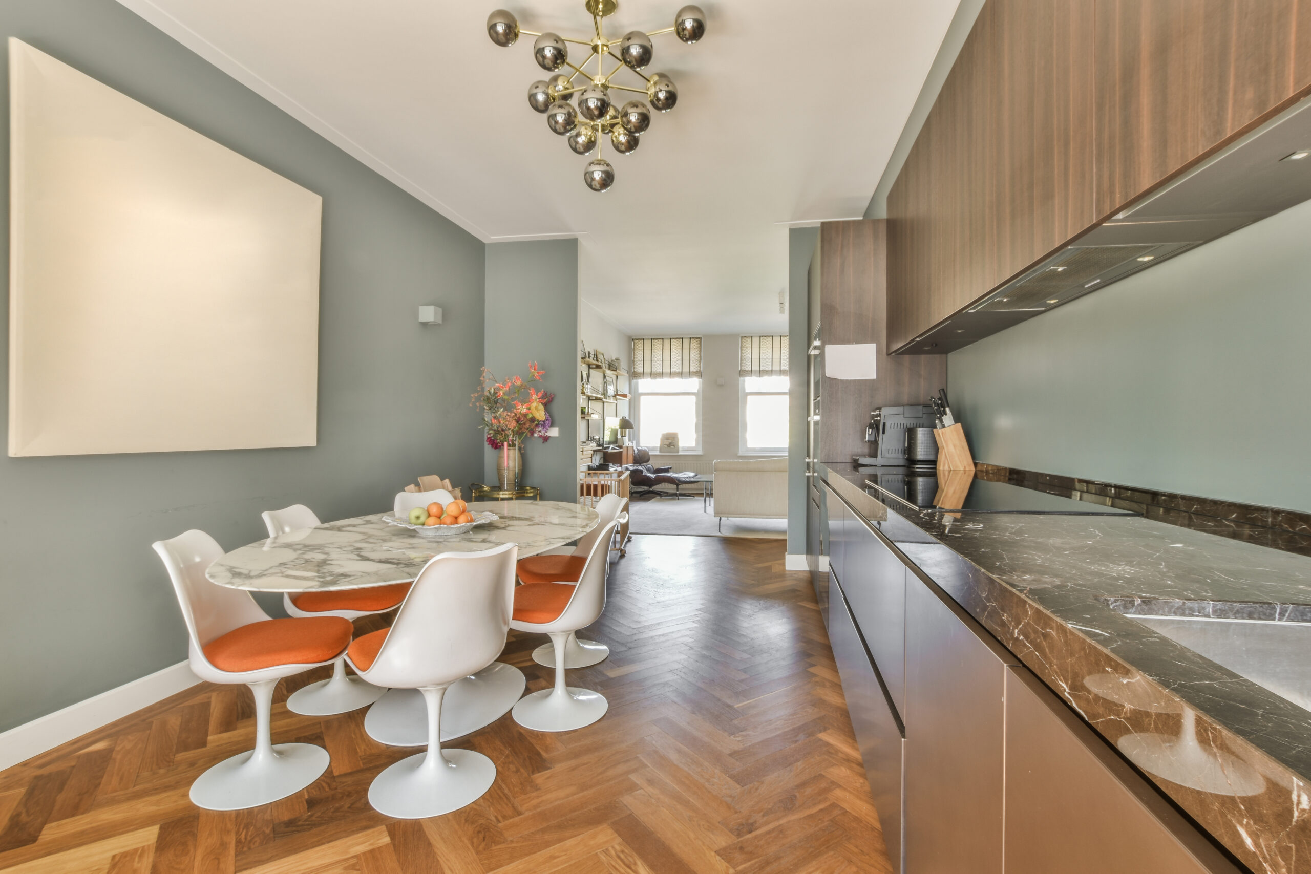 Home interior design of modern loft apartment with open kitchen in minimalist style and spacious dining zone with table and chairs