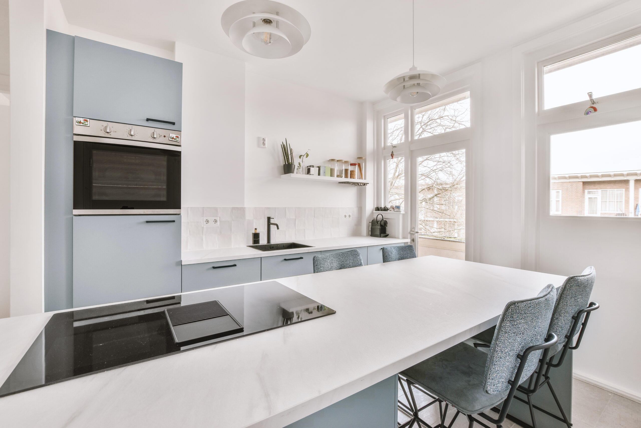 Home interior design of modern loft apartment with open kitchen in minimalist style and spacious dining zone with table and chairs