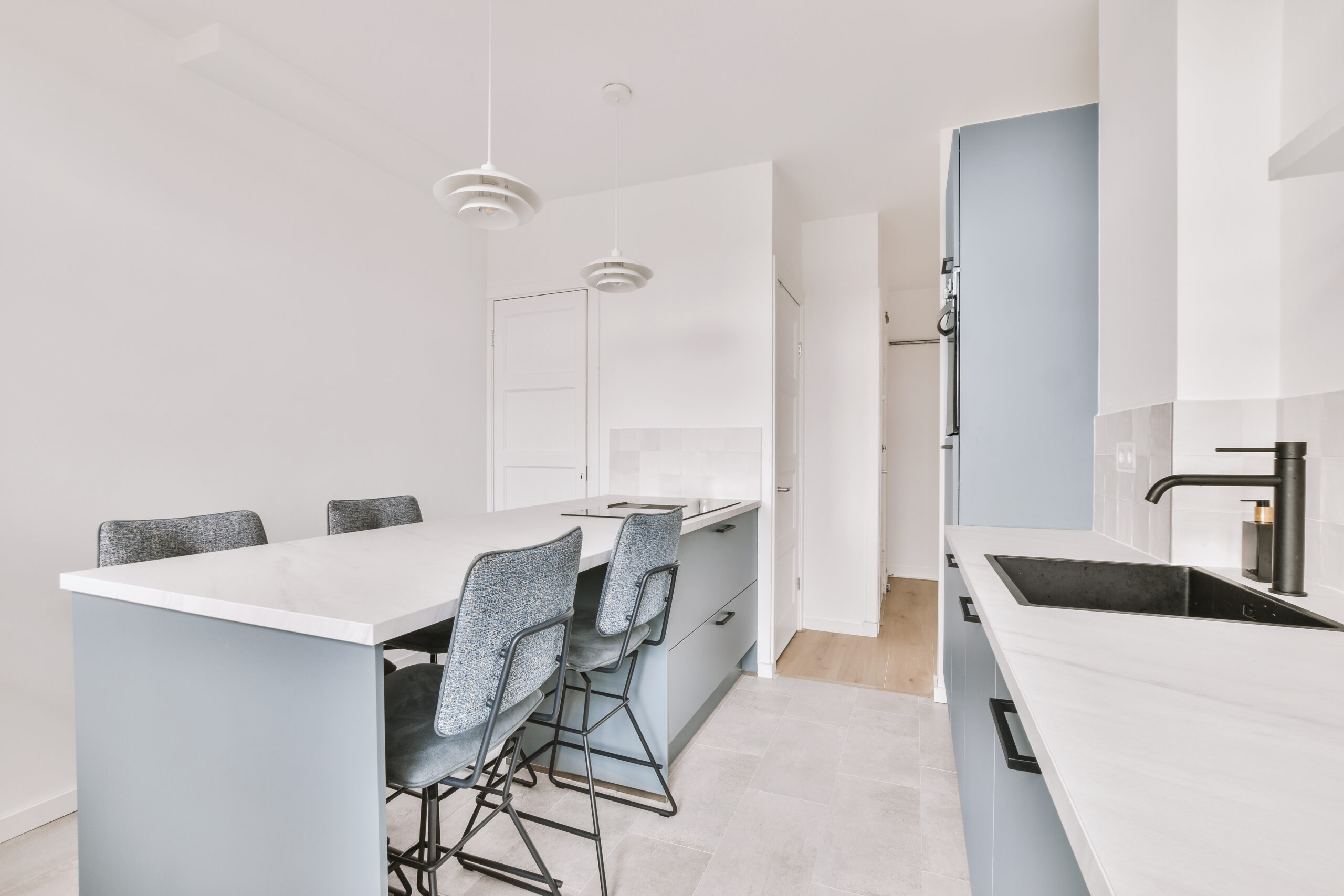 Home interior design of modern loft apartment with open kitchen in minimalist style and spacious dining zone with table and chairs