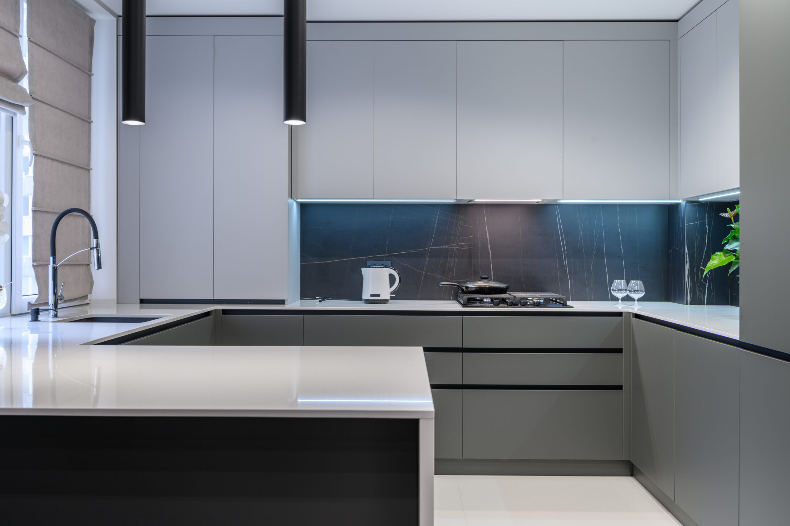 Elegant white and grey luxury kitchen, dining room with kitchen bar and stools in studio apartment interior