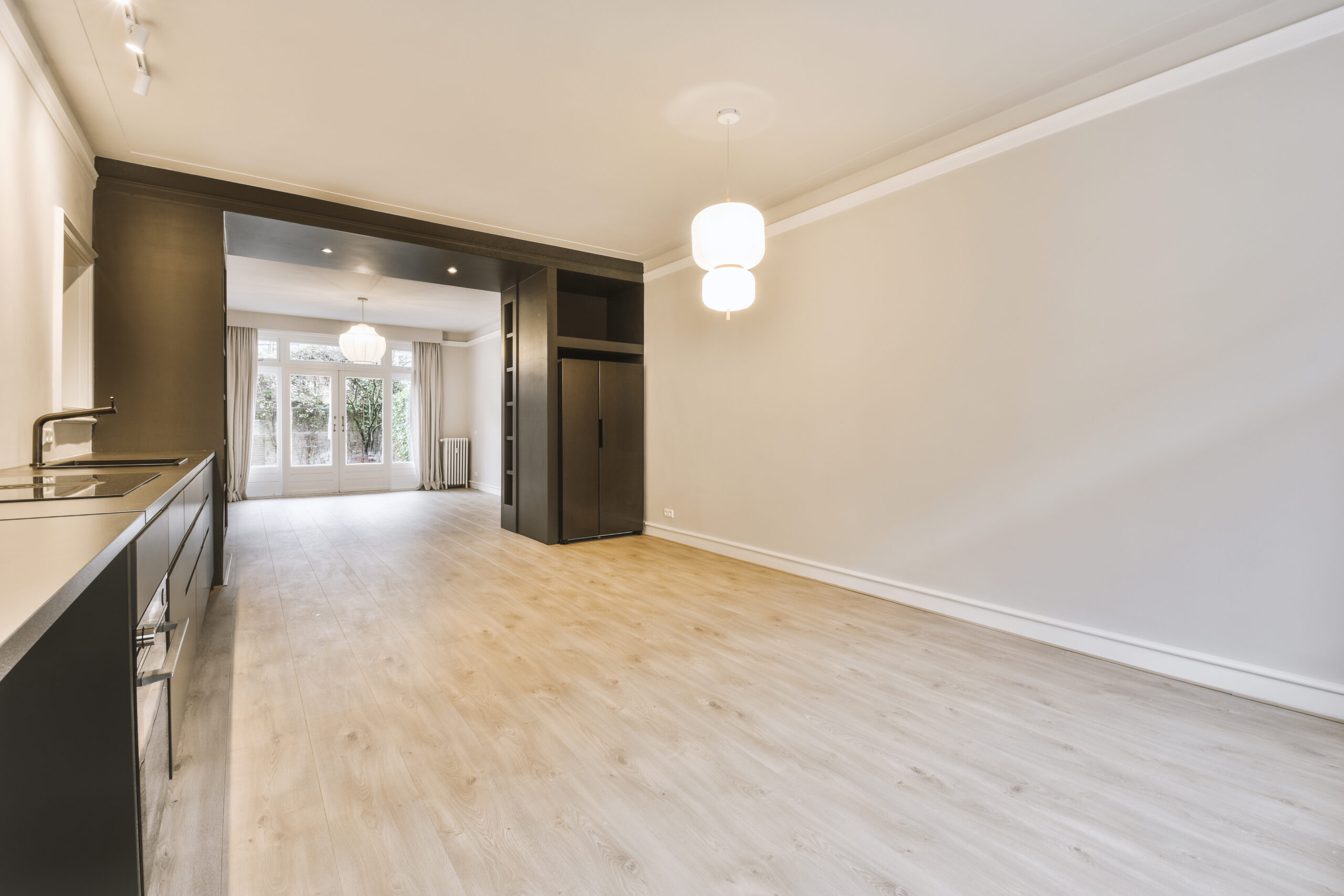 Interior of empty white kitchen with windows and wooden parquet floor